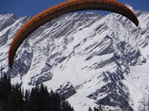Парапланеризм и на заднем плане там красивый снег покрыл moutains Индии стоковая фотография rf Парапланеризм и на заднем плане там красивый снег покрыл moutains Индии стоковая фотография rf