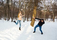 Парень и девушка бросают снежные комья на один другого в зиме снаружи стоковые фотографии rf Парень и девушка бросают снежные комья на один другого в зиме снаружи стоковые фотографии rf