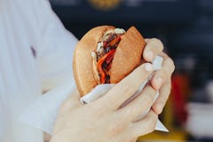Парень сдерживает бургер крен с завалкой мясо в середине Сильные оружия E фаст-фуд стоковая фотография Парень сдерживает бургер крен с завалкой мясо в середине Сильные оружия E фаст-фуд стоковая фотография