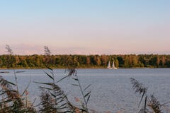 Парусник на спокойном озере с отражением в воде Спокойный ландшафт сцены Горизонтальный фотоснимок стоковое фото Парусник на спокойном озере с отражением в воде Спокойный ландшафт сцены Горизонтальный фотоснимок стоковое фото