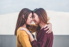 Пары Азии лесбосские LGBT обнимают и обнюхивают поцелуй на крыше buildin стоковое изображение Пары Азии лесбосские LGBT обнимают и обнюхивают поцелуй на крыше buildin стоковое изображение
