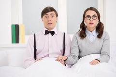 Пары болвана. Удивленные пары болвана сидя на кровати и lookin стоковое изображение Пары болвана. Удивленные пары болвана сидя на кровати и lookin стоковое изображение