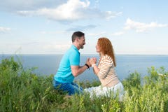 Пары в flirts влюбленности на пляже Парень держит руки девушки и привлекает к себе Портрет счастливой пары стоковое изображение rf Пары в flirts влюбленности на пляже Парень держит руки девушки и привлекает к себе Портрет счастливой пары стоковое изображение rf