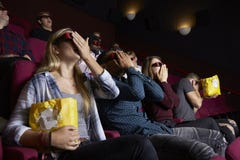 Пары в кино нося стекла 3D смотря фильм ужасов стоковая фотография rf Пары в кино нося стекла 3D смотря фильм ужасов стоковая фотография rf