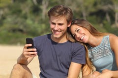 Пары подростка деля социальные средства массовой информации на умном телефоне стоковая фотография rf Пары подростка деля социальные средства массовой информации на умном телефоне стоковая фотография rf