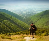 Пары туристов с рюкзаками na górze высокой горы стоковые фотографии rf Пары туристов с рюкзаками na górze высокой горы стоковые фотографии rf