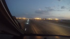 Пассажирский самолет принимает от авиапорта на восходе солнца, взгляда от арены Пассажирский самолет принимает от авиапорта на восходе солнца, взгляда от арены