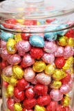 Пасхальные яйца в предпосылке стеклянного опарника конфеты multicolor Стоковые Фото Пасхальные яйца в предпосылке стеклянного опарника конфеты multicolor Стоковые Фото