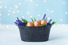 Пасхальные яйца в старом шаре, трава, цветки на голубой предпосылке с bokeh Концепция пасхи и весны стоковая фотография rf Пасхальные яйца в старом шаре, трава, цветки на голубой предпосылке с bokeh Концепция пасхи и весны стоковая фотография rf