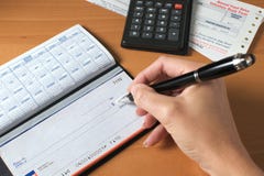 пер получки удерживания руки проверки счетов к сочинительству стоковые фотографии rf пер получки удерживания руки проверки счетов к сочинительству стоковые фотографии rf