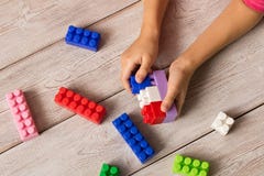 Пестротканый пластиковый конструктор в руках девушки Игры ` s детей воспитательные стоковая фотография Пестротканый пластиковый конструктор в руках девушки Игры ` s детей воспитательные стоковая фотография