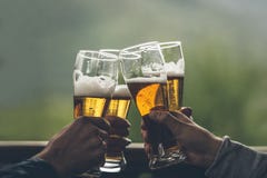 Пиво с мальчиками света пены высокорослыми в руках друзей поднимая a стоковые фото Пиво с мальчиками света пены высокорослыми в руках друзей поднимая a стоковые фото