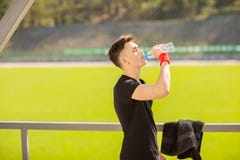 Питьевая вода человека фитнеса от бутылки Испытывающий жажду спортсмен имея холодный напиток освежения после интенсивной трениров стоковые фотографии rf Питьевая вода человека фитнеса от бутылки Испытывающий жажду спортсмен имея холодный напиток освежения после интенсивной трениров стоковые фотографии rf