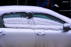 Плавя снег на крыше и окнах автомобиля стоковое фото rf Плавя снег на крыше и окнах автомобиля стоковое фото rf