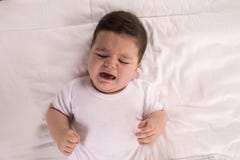 плакать ребёнка Ребенок новорожденного утомлянный и голодный в кровати Childre стоковые фотографии rf плакать ребёнка Ребенок новорожденного утомлянный и голодный в кровати Childre стоковые фотографии rf