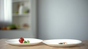 Плита с натуральными продуктами против таблеток для потери веса, выбирающ здоровое питание или лекарства стоковое изображение rf Плита с натуральными продуктами против таблеток для потери веса, выбирающ здоровое питание или лекарства стоковое изображение rf
