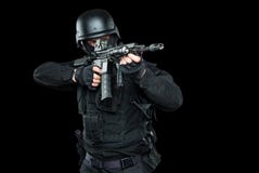 Полицейский СВАТ ops спецификаций в черной равномерной студии стоковые изображения Полицейский СВАТ ops спецификаций в черной равномерной студии стоковые изображения