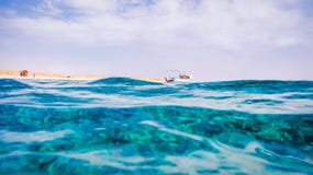 Поверхность Красного Моря в Marsa Alam, шлюпке Fisher и пустыне в предпосылке стоковые изображения rf Поверхность Красного Моря в Marsa Alam, шлюпке Fisher и пустыне в предпосылке стоковые изображения rf