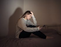 Подавленная девушка подростка на жертве мобильного телефона cyberbullying чувства грустной, несчастной и сиротливой стоковые изображения Подавленная девушка подростка на жертве мобильного телефона cyberbullying чувства грустной, несчастной и сиротливой стоковые изображения