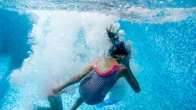 Подводное изображение девочка-подростка 2 скача и ныряя в бассейне на спортзале стоковое фото rf Подводное изображение девочка-подростка 2 скача и ныряя в бассейне на спортзале стоковое фото rf