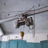 Подкрановая балка с двигателем и крюком, вися на стальных веревочках, промышленный кран подвеса стоковая фотография rf Подкрановая балка с двигателем и крюком, вися на стальных веревочках, промышленный кран подвеса стоковая фотография rf