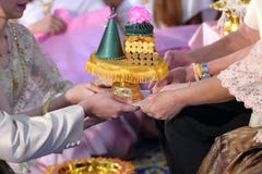 Поднос Groom и невесты предлагая подарка к старой в традиционной тайской свадебной церемонии Концепция замужества Стоковое Изображение RF Поднос Groom и невесты предлагая подарка к старой в традиционной тайской свадебной церемонии Концепция замужества Стоковое Изображение RF