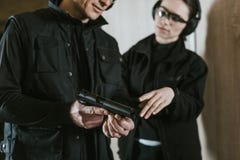 подрезанное изображение инструктора показывая оружие к женскому клиенту стоковые изображения rf подрезанное изображение инструктора показывая оружие к женскому клиенту стоковые изображения rf