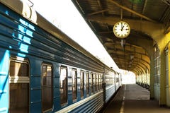 Поезд стоит на платформе станции Часы станции стоковые изображения Поезд стоит на платформе станции Часы станции стоковые изображения