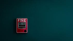 Пожарная сигнализация на темной ой-зелен бетонной стене Предупреждение и система безопасности Аварийное оборудование для сигнала стоковые фотографии rf Пожарная сигнализация на темной ой-зелен бетонной стене Предупреждение и система безопасности Аварийное оборудование для сигнала стоковые фотографии rf