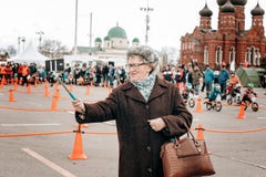 Пожилая женщина в пальто и берете делает selfie с помощью ручке selfie стоковая фотография Пожилая женщина в пальто и берете делает selfie с помощью ручке selfie стоковая фотография