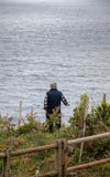 Пожилой человек от за наблюдать море на Атлантика скале в Галиции, Испании стоковое изображение rf Пожилой человек от за наблюдать море на Атлантика скале в Галиции, Испании стоковое изображение rf