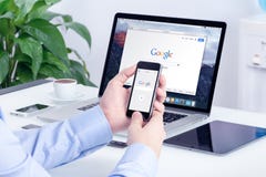 Поиск Google на экране iPhone Яблока и дисплее Macbook Pro стоковые изображения rf Поиск Google на экране iPhone Яблока и дисплее Macbook Pro стоковые изображения rf