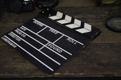Покинутые фильм шифера или колотушка кино на пакостном деревянном столе стоковые фотографии rf Покинутые фильм шифера или колотушка кино на пакостном деревянном столе стоковые фотографии rf