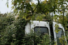 Покинутый увиденный автомобиль неиндивидуального пользования вставленным в живой изгороди стоковые изображения rf Покинутый увиденный автомобиль неиндивидуального пользования вставленным в живой изгороди стоковые изображения rf