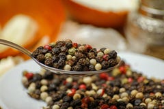 Покрашенное смешивание специи перцев в ложке и на небольшой керамической плите стоковое фото Покрашенное смешивание специи перцев в ложке и на небольшой керамической плите стоковое фото