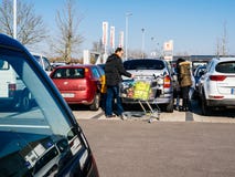 Покупки семьи для еды в автостоянке супермаркета Kaufland стоковая фотография Покупки семьи для еды в автостоянке супермаркета Kaufland стоковая фотография