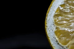 Половинная деталь на черной изолированной предпосылке, конец куска лимона вверх, стоковая фотография rf Половинная деталь на черной изолированной предпосылке, конец куска лимона вверх, стоковая фотография rf