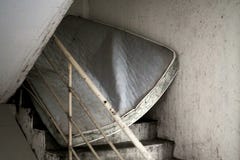 Получившийся отказ грязный тюфяк преграждая запятнанную лестницу из-под стоковое изображение Получившийся отказ грязный тюфяк преграждая запятнанную лестницу из-под стоковое изображение