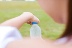 Попытка женщины для того чтобы раскрыть воду бутылки ее рукой стоковые изображения rf Попытка женщины для того чтобы раскрыть воду бутылки ее рукой стоковые изображения rf