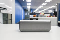 Портативный беспроволочный громкий диктор в офисе для слушать к музыке Стоковые Изображения Портативный беспроволочный громкий диктор в офисе для слушать к музыке Стоковые Изображения