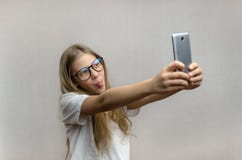 Портрет белокурой девушки которая принимает selfie на ее смартфоне Современные технологии Молодой блоггер стоковая фотография Портрет белокурой девушки которая принимает selfie на ее смартфоне Современные технологии Молодой блоггер стоковая фотография