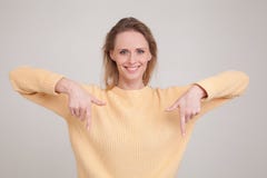 Портрет белокурой женщины указывая вниз как усмехаться дружелюбный и gazing на камере предлагая ot продукта попытки взглянет на к стоковые фото Портрет белокурой женщины указывая вниз как усмехаться дружелюбный и gazing на камере предлагая ot продукта попытки взглянет на к стоковые фото
