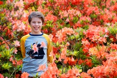Портрет весны милого привлекательного 10 - летнего мальчика представляя в саде рядом с цвести розовым рододендроном стоковое изображение Портрет весны милого привлекательного 10 - летнего мальчика представляя в саде рядом с цвести розовым рододендроном стоковое изображение