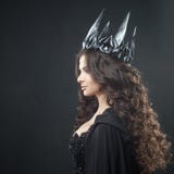 Портрет готической принцессы Красивая молодая женщина брюнет в кроне металла и черном плаще стоковые изображения rf Портрет готической принцессы Красивая молодая женщина брюнет в кроне металла и черном плаще стоковые изображения rf