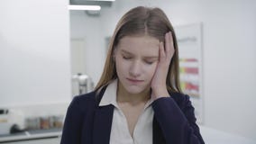 Портрет грустной уставшей молодой дамы в официальных одеждах смотря в камере Женщина с длинными волосами имела головную боль, она сток-видео Портрет грустной уставшей молодой дамы в официальных одеждах смотря в камере Женщина с длинными волосами имела головную боль, она сток-видео