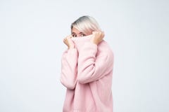 Портрет девушки вытягивая ее розовые накладные расходы свитера Женщина при вспугнутый взгляд исчезая в ее одеждах стоковые фотографии rf Портрет девушки вытягивая ее розовые накладные расходы свитера Женщина при вспугнутый взгляд исчезая в ее одеждах стоковые фотографии rf
