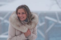 Портрет зимы женщины в белом пальто во время снежностей в парке Стоковое Изображение Портрет зимы женщины в белом пальто во время снежностей в парке Стоковое Изображение