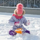 Портрет зимы на открытом воздухе девушки ребенка усмехаясь и играя со снегом, ярким солнечным зимним днем стоковые изображения Портрет зимы на открытом воздухе девушки ребенка усмехаясь и играя со снегом, ярким солнечным зимним днем стоковые изображения