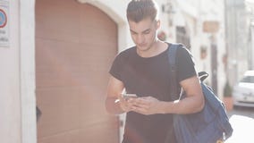 Портрет красивого smartphone и идти молодого человека занимаясь серфингом о городке предпосылка солнечная запачканная предпосылка видеоматериал Портрет красивого smartphone и идти молодого человека занимаясь серфингом о городке предпосылка солнечная запачканная предпосылка видеоматериал