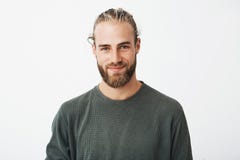 Портрет красивого зрелого белокурого бородатого парня с ультрамодным hairdo в вскользь серой рубашке усмехаясь и смотря в камере стоковое фото rf Портрет красивого зрелого белокурого бородатого парня с ультрамодным hairdo в вскользь серой рубашке усмехаясь и смотря в камере стоковое фото rf
